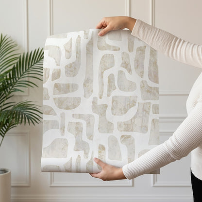 Bright Stones abstract stone-shape wallpaper in warm ivory and sand shown on a single wallpaper drop