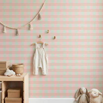 Pastel check wallpaper in a nursery with bunting, little dungarees on a hook and wooden crates