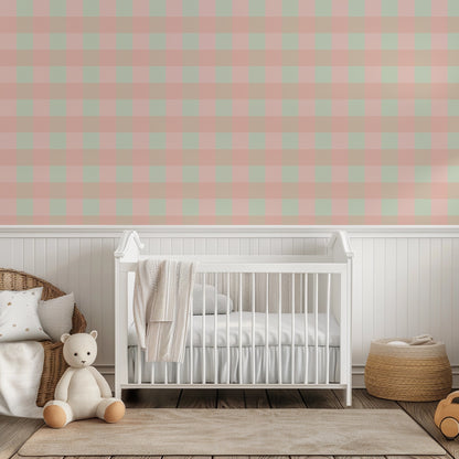 Blush, mint and sandy tan check wallpaper above white panelling behind a white cot