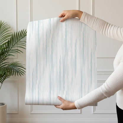 Graphite Lines wallpaper roll drop showing the brushed blue-grey pinstripe repeat