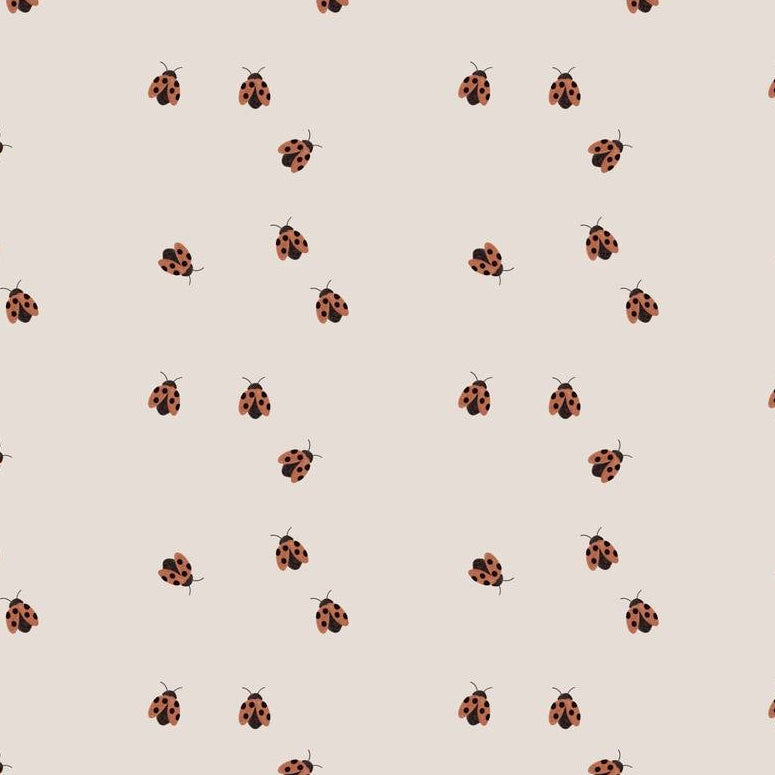 Ladybugs wallpaper design — tiny hand-painted red ladybugs scattered on a warm oat ground